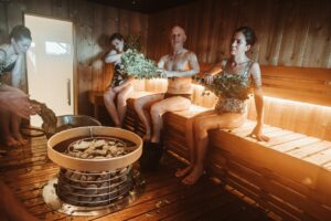 Group of people enjoying a traditional Nordic sauna with natural sauna whisking.