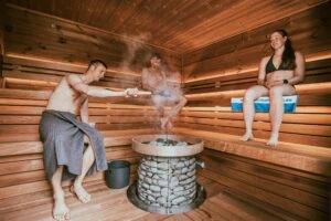 Three people enjoying a steamy sauna session, embracing wellness and relaxation.